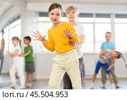 Girl paired up with boy and training to perform boogie woogie couple dance, rehearse performance. Стоковое фото, фотограф Яков Филимонов / Фотобанк Лори