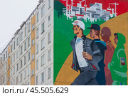 Город Тында, Амурская область, Россия. Вид на большое граффити на стене жилого дома, посвящённое строителям Байкало-Амурской магистрали (БАМ) и города Тынды. Красивый мурал с изображением молодых энергичных людей, идущих на стройку. Крупный план. (2024 год). Редакционное фото, фотограф Андрей Степанов / Фотобанк Лори