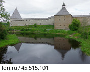 Стрелочная и Воротная башни отражаются в водах реки Ладожки. Староладожская крепость, село Старая Ладога, Ленинградская область (2019 год). Редакционное фото, фотограф Алексей Иванов / Фотобанк Лори