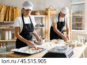 Elderly man and woman molding and greasing pieces of dough. Стоковое фото, фотограф Татьяна Яцевич / Фотобанк Лори