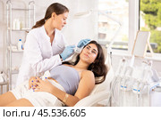 Aesthetician administering hardware facial procedure with ice hammer on young woman. Стоковое фото, фотограф Яков Филимонов / Фотобанк Лори