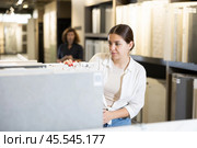 woman is considering MDF boards for internal insulation of residential premises. Стоковое фото, фотограф Яков Филимонов / Фотобанк Лори