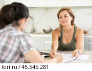 Woman manager tells girl client about specifics of design of microloan about benefits and advantages. Стоковое фото, фотограф Яков Филимонов / Фотобанк Лори