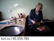 27.01.2023, Жостово. Художник рисует цветы на подносе на Жостовской фабрике. Редакционное фото, фотограф Дмитрий Киселёв / Фотобанк Лори