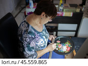 27.01.2023, Жостово. Женщина-художник Жостовской фабрики декоративной росписи за работой. Редакционное фото, фотограф Дмитрий Киселёв / Фотобанк Лори