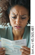 Stressed young woman reading invoices and calculating domestic bills at home office desk. Стоковое AI-видео, аниматор Юрий Поздников / Фотобанк Лори