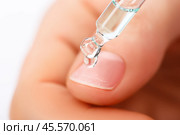 Пипетка с каплей средства по уходу за ногтями или средством против грибковых инфекций, крупным планом. Стоковое фото, фотограф Александр Маликов / Фотобанк Лори