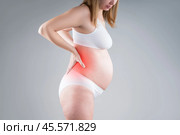 Pregnant woman with back pain, kidney inflammation, risk of premature birth, health problems during pregnancy. Стоковое фото, фотограф Станислав Тарко / Фотобанк Лори