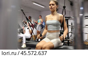 Active athlete young woman during exercises on crossover exercise machine with loops and weighting. Стоковое видео, видеограф Яков Филимонов / Фотобанк Лори