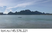 Sunny Thailand seascape with boat gliding across calm waters and mountains in the background. Стоковое видео, видеограф Людмила Лесовая / Фотобанк Лори