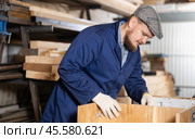 Male furniture assembler assembles wooden table at furniture factory. Стоковое фото, фотограф Яков Филимонов / Фотобанк Лори