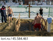 Люди купаются в проруби на праздник Крещения в Воронцовском парке, Москва (2022 год)./ Epiphany bathing in the ice hole in the Vorontsovo estate, Moscow. Редакционное фото, фотограф Iva Noel / Фотобанк Лори