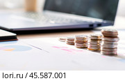 22 percent income tax on personal income in Russia from 2025. Tax reform. A stack of coins sits on a table next to a laptop. The coins are arranged in a pyramid shape, with the largest coin. Стоковое фото, фотограф Скрипачев Антон / Фотобанк Лори