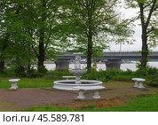 Фонтан, превращённый в клумбу, на фоне Карельского моста. Набережная Ладожской Флотилии, Сортавала, Карелия (2019 год). Редакционное фото, фотограф Алексей Иванов / Фотобанк Лори