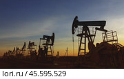 Many working oil pumps silhouette against sunset. Стоковое видео, видеограф Михаил Коханчиков / Фотобанк Лори