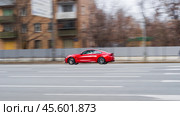 Red aggressive BMW Sport Car riding on the road. Side view of shiny bmw M4 F82 driving in the street. (2021 год). Редакционное фото, фотограф Константин Григорьев / Фотобанк Лори