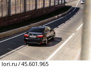 Toyota camry XV50 in motion, rear side view. Aerial photography of a shiny black sedan riding in Moscow streets (2021 год). Редакционное фото, фотограф Константин Григорьев / Фотобанк Лори