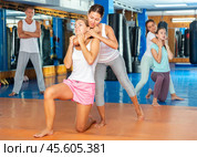 Asian woman performing rear choke hold while sparring with female opponent. Стоковое фото, фотограф Яков Филимонов / Фотобанк Лори