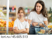 Mom calms down her capricious daughter who wants to buy sweets at supermarket. Стоковое фото, фотограф Яков Филимонов / Фотобанк Лори