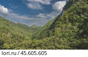 Beautiful mountain landscape. The slopes are overgrown with impenetrable green forest. Blue sky, clouds. It's a sunny day. China. Tianxingqiao Scenic Area. Guiyang. Guizhou. Стоковое фото, фотограф Вера Ивановна Кубарева / Фотобанк Лори