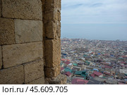 Top view of the ancient city from the loophole of the fortress. The Caspian Sea stretches beyond the houses of the city of Derbent. View of the old quarters of Derbent from the Naryn-Kala fortress. Стоковое фото, фотограф Эдуард Белкин / Фотобанк Лори