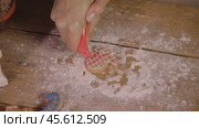 Process of creating gingerbread cookies shaped like mitten, with red sweet icing, on wooden table, with ingredients and flour. Стоковое видео, видеограф Strunov David / Фотобанк Лори