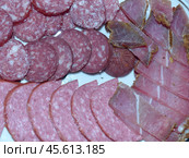 Мясная тарелка или ассорти – это красивая подача колбасок, мяса, приготовленного разными способами, буженины и других деликатесов. Стоковое фото, фотограф Сергей Елизарьев / Фотобанк Лори