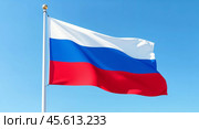 Российский флаг на флагштоке на фоне голубого неба. Флаг Российской Федерации крупным планом. Символ России. Стоковое AI-изображение, AI-художник Ирина / Фотобанк Лори