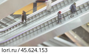 People in motion in escalators at the modern shopping mall. Tilt shift lens shooting with super shallow depth of field. Стоковое видео, видеограф Андрей Армягов / Фотобанк Лори