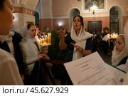 07.01.2023. Раменское, Троицкий собор. Женщина дирижирует церковным хором во время литургии на Рождественской службе. Редакционное фото, фотограф Дмитрий Киселёв / Фотобанк Лори