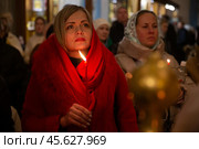 16.04.2023, Истра. Женщина-прихожанка с горящей свечой в руке во время Пасхальной службы в Cтавропигиальном Воскресенском Новоиерусалимском мужском монастыре Русской православной церкви. Редакционное фото, фотограф Дмитрий Киселёв / Фотобанк Лори