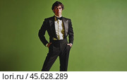 Confident man in elegant suit posing against green backdrop. Стоковое AI-видео, аниматор Sabyna75 / Фотобанк Лори