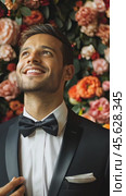 Joyful man in tuxedo smiling by vibrant floral wall. Стоковое AI-видео, аниматор Sabyna75 / Фотобанк Лори