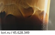 Cream swirling dramatically into dark coffee glass creating hypnotic patterns. Стоковое AI-видео, аниматор Sabyna75 / Фотобанк Лори