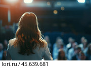 A dynamic young female speaker captivates an audience during an informative training seminar. Colleagues and students are engaged and attentive to her presentation. Стоковое AI-изображение, AI-художник Sergey Grishin / Фотобанк Лори