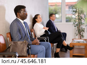 Middle-aged male visitor sitting on the bench in waiting room of clinic. Стоковое фото, фотограф Яков Филимонов / Фотобанк Лори
