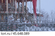 Москва, Россия - 07 декабря 2024 г.: Карусель на площадке фестиваля "Московские сезоны" в Люблино. Крупный план детского аттракциона с лошадками и новогодними огнями. Сильный снегопад. Замедленная съемка. Редакционное видео, видеограф Светлана Ельцова / Фотобанк Лори