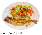There is plate with fried solea flatfish and salad of fresh veg on wooden table. Стоковое фото, фотограф Яков Филимонов / Фотобанк Лори