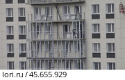 ANGARSK, IRKUTSK REGION, RUSSIA - October 08, 2024: Video of builders work on new high-rise modern residential building and glazing balconies. Housing construction concept. Редакционное видео, видеограф Виктория Катьянова / Фотобанк Лори