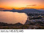 Picturesque view of sunset over the embankment of the city of Sudak in the mountainous area of ​​the southern coast of Crimea (2021 год). Стоковое фото, фотограф Константин Лабунский / Фотобанк Лори