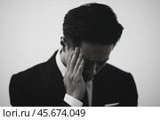 A man in a suit, covering his face with his hand. The concept of mental and mental health. Стоковое AI-изображение, AI-художник Ярославский Максим / Фотобанк Лори