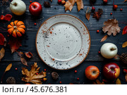 White plate on autumn background. Rustic menu mockup fall table setting decoration, colorful leaves. Floral interior decor for holidays with pumpkins. Thanksgiving dinner concept. Flatlay, top view. Стоковое AI-изображение, AI-художник Марина Демидюк / Фотобанк Лори