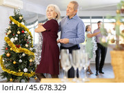 Smiling elderly woman and partner successfully perform mesmerizing movements of paso doble dance during celebration Christmas and New Year. Стоковое фото, фотограф Яков Филимонов / Фотобанк Лори