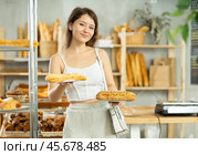 Portrait of a young girl with a bocadillo in her hands in the interior of private bakery. Стоковое фото, фотограф Яков Филимонов / Фотобанк Лори