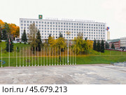 Административное здание с лозунгом на Белорусском языке на центральной улице Витебска в районе летнего амфитеатра. Осенние деревья окрашены в желтые и оранжевые цвета, создавая теплую атмосферу. Редакционное фото, фотограф Сергей Никифоров-Гордеев / Фотобанк Лори