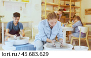 Portrait of a ceramics teacher with students and finished works after a master class. Teenage girl show clay products made themselves in the art studio. Стоковое видео, видеограф Яков Филимонов / Фотобанк Лори