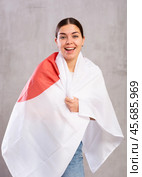 Joyous young woman holding Japan flag against unicoloured background. Стоковое фото, фотограф Яков Филимонов / Фотобанк Лори