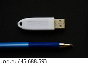 Устройство  USB eToken  (рутокен) – электронная подпись - белого цвета  и ручка на тёмном фоне. Редакционное фото, фотограф Snezka / Фотобанк Лори