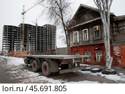 Старый  дом времен Российской империи в исторической части старого города Астрахань ( Южная часть города ). С обеих сторон надвигаются новостройки, и он обречен на снос (2018 год). Стоковое фото, фотограф Павел Просянов / Фотобанк Лори
