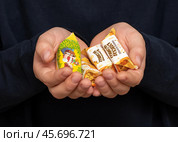 Ребёнок держит в ладошках конфеты. Редакционное фото, фотограф Игорь Низов / Фотобанк Лори